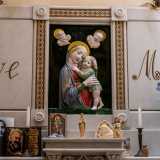 ...e decorato con statuette, candele e immagini sacre